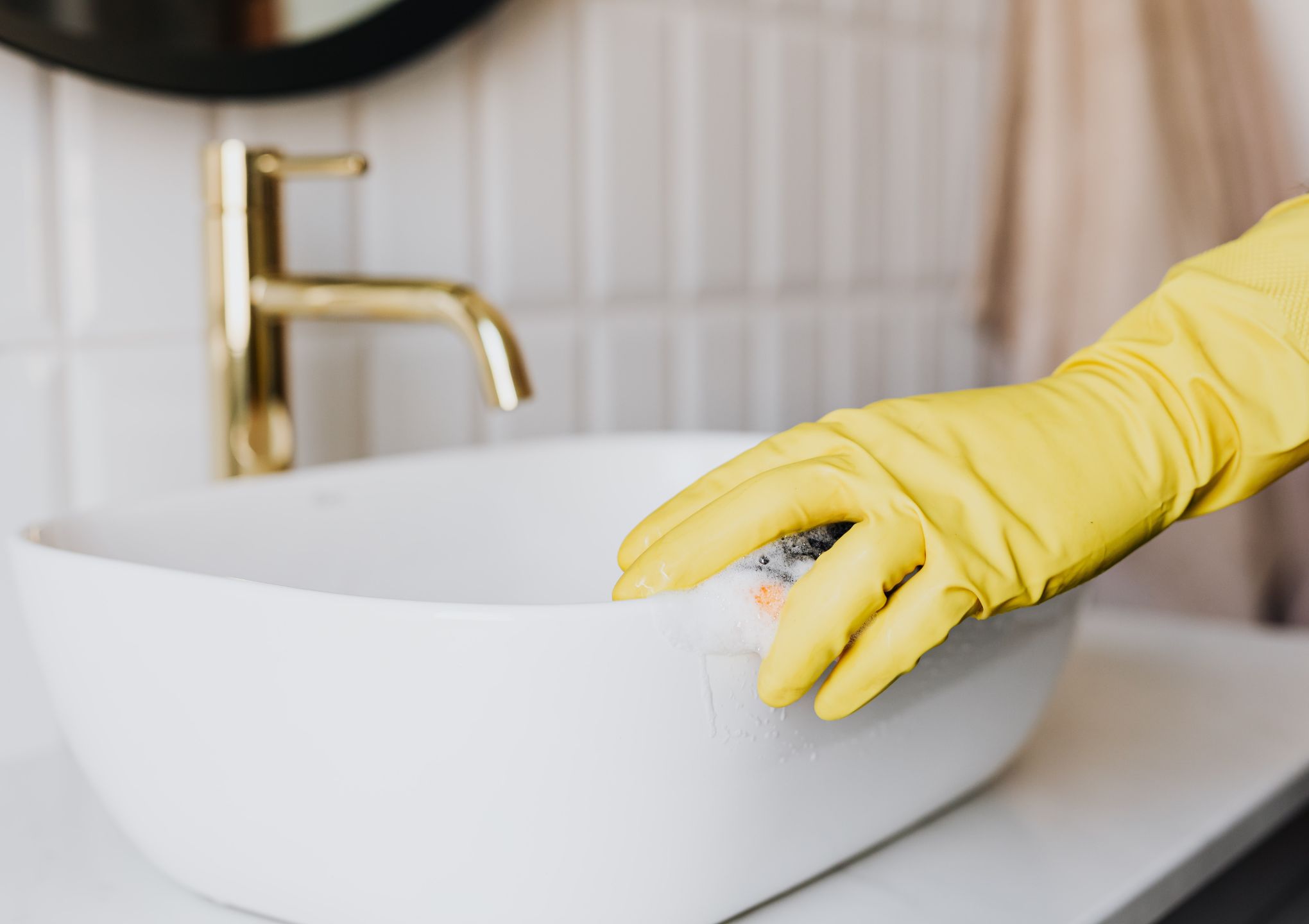 the house cleaner is washing the basin in the toilet - Post Featured Image